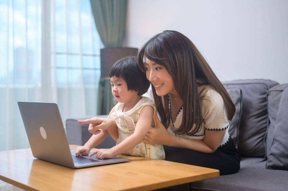 Free Image of Mother showing young child something on a laptop computer 