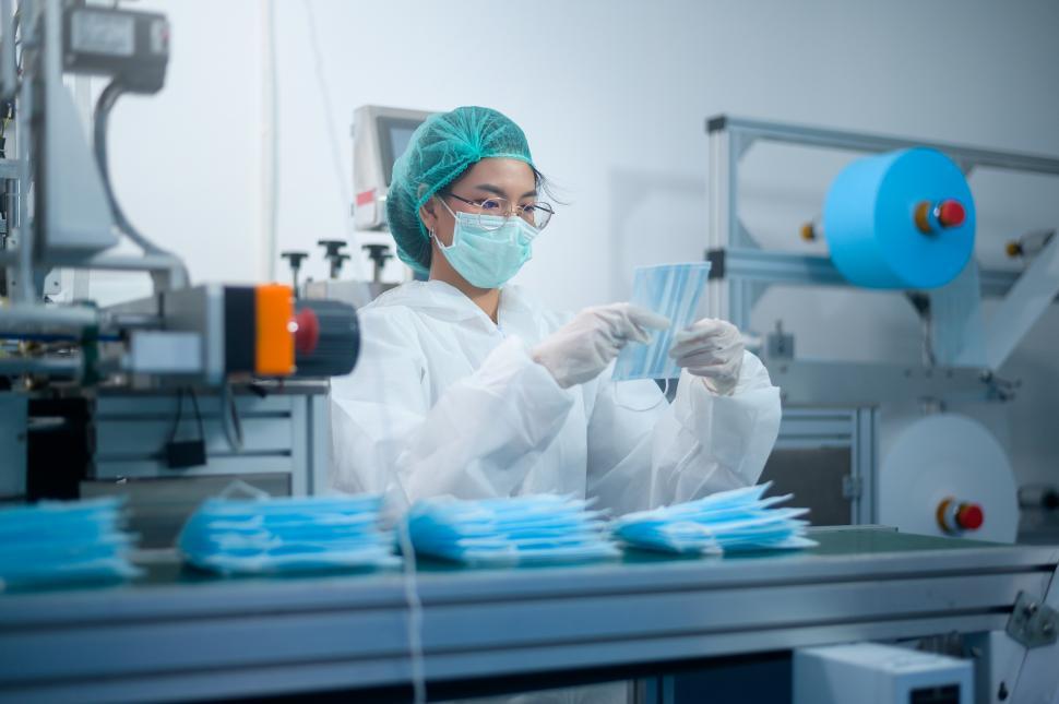 Free Image of Workers producing surgical mask in modern factory assembly line 