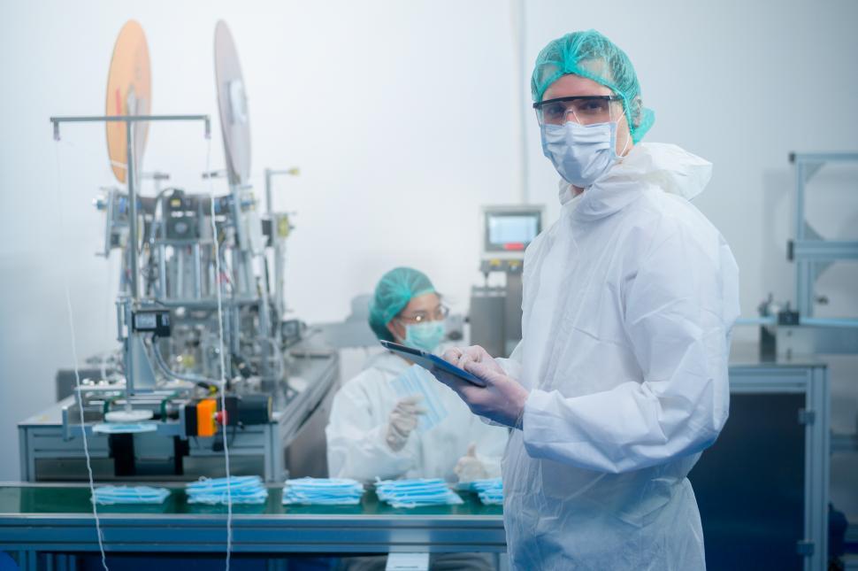 Free Image of Workers in clean gear producing surgical mask in modern factory 