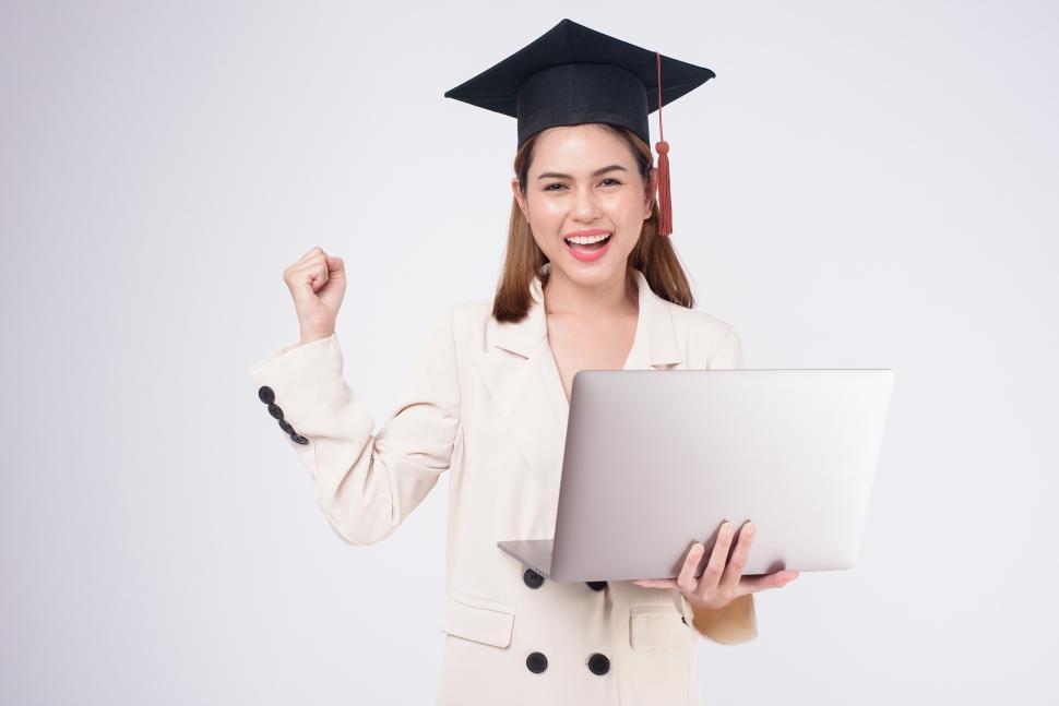 Free Image of Portrait of young woman graduate with open laptop computer 