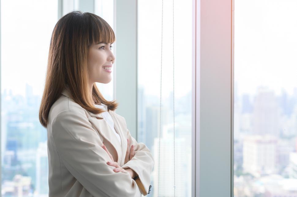 Free Image of Portrait of young businesswoman looking out the window of a modern office 