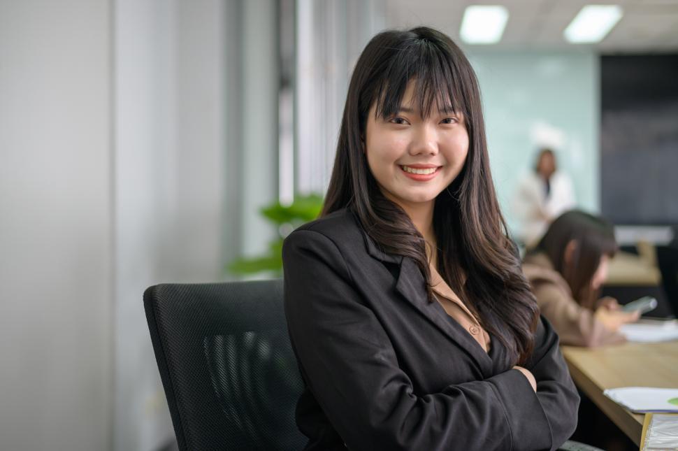 Free Image of Portrait of seated Asian business woman smiling in office 
