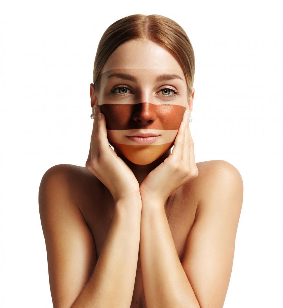 Free Image of woman looking at camera with stripes of different foundation base on her face 