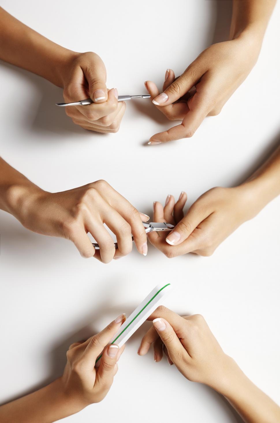 Free Image of Female hands showing process of a manicure, white background 