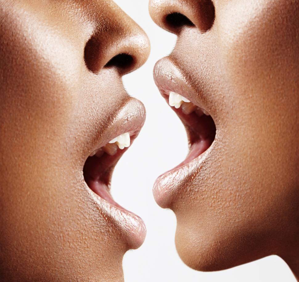 Free Image of Two women facing each other in profile with open mouths - extreme close up 