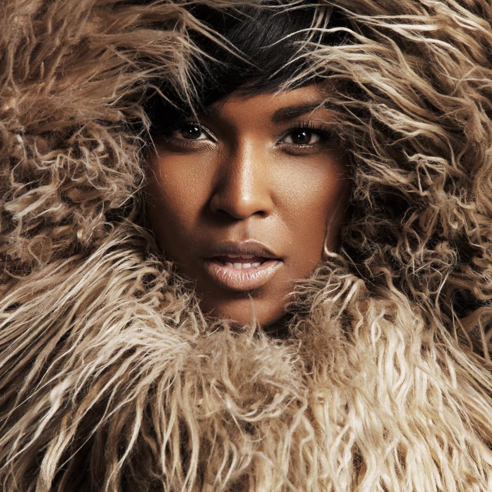 Free Image of Woman looking out from deep within the fur 