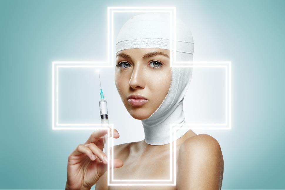 Free Image of woman holding injection with graphic overlay of medical cross 