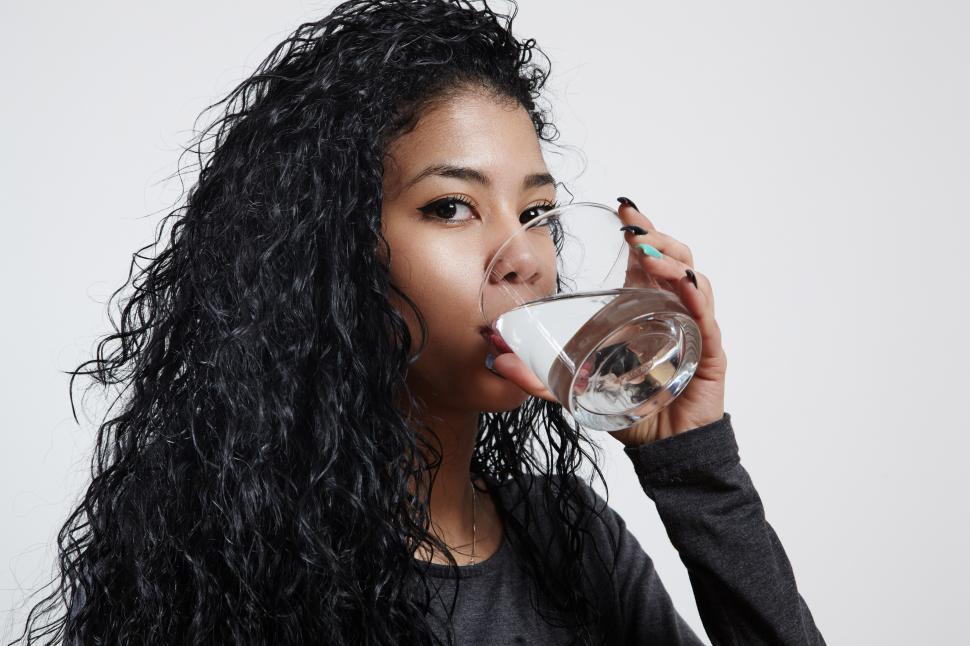 Free Image of gurl with a curly hair is drinking a water 