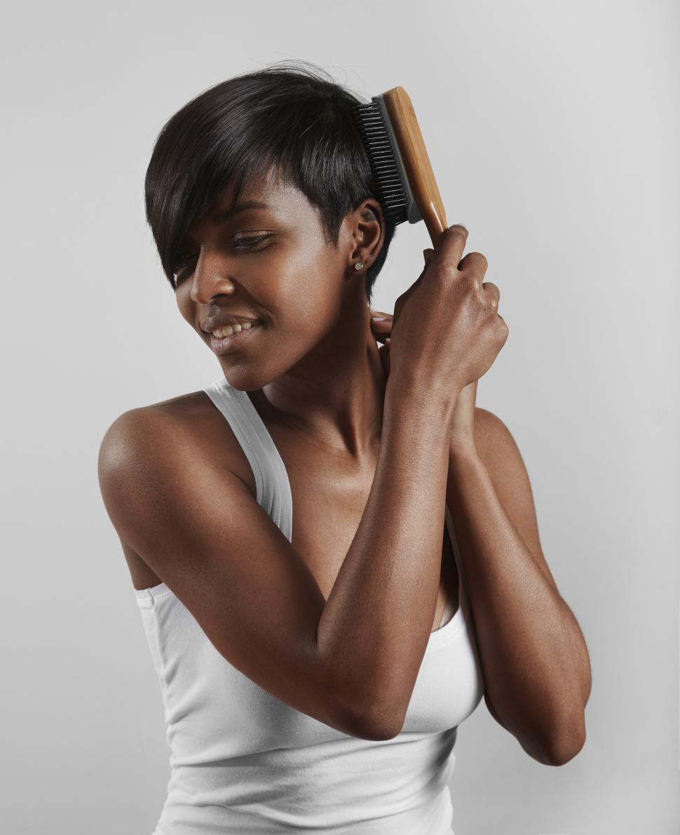 Free Image of black woman with a short hair and hair brush 