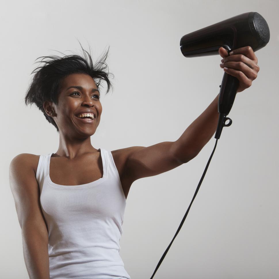 Free Image of happy woman with a short haircut and hair dryer 