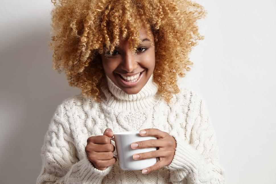 Free Image of woman wears knitted sweater and holding a mug of hot beverage 