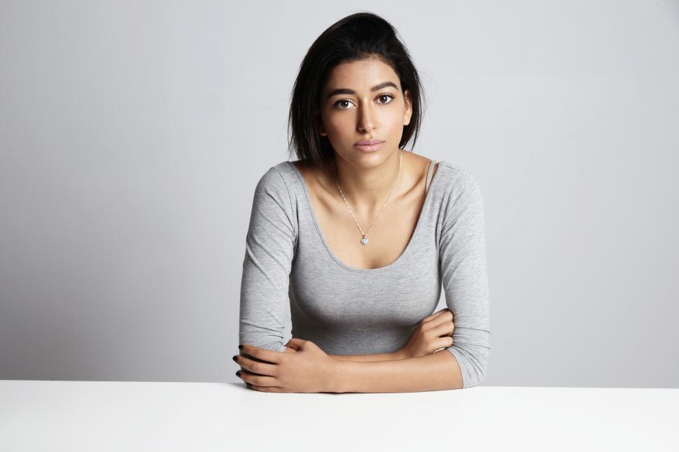 Free Image of neutral emotionless woman in grey top in studio shoot 