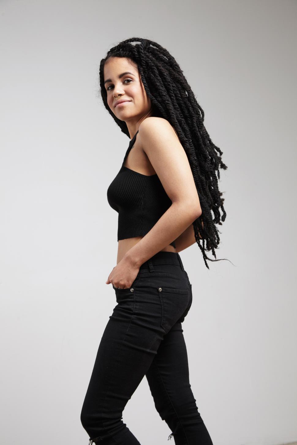 Free Image of young teen girl with braids dreads, wearing jeans, looking at camera 