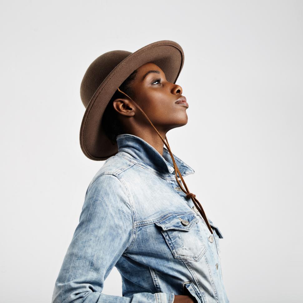 Free Image of black woman in hat and demin jacket shown in profile 