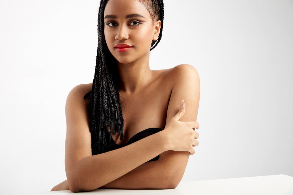 Free Image of black woman with braids in studio shoot, arms crossed 