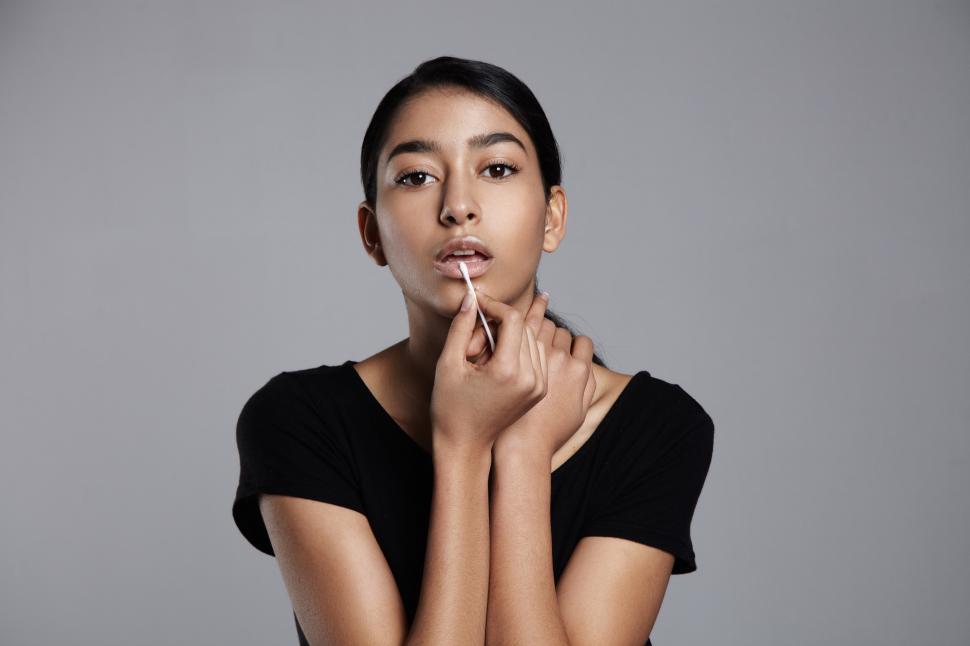 Free Image of young woman with cotton swab correcting the lipline 