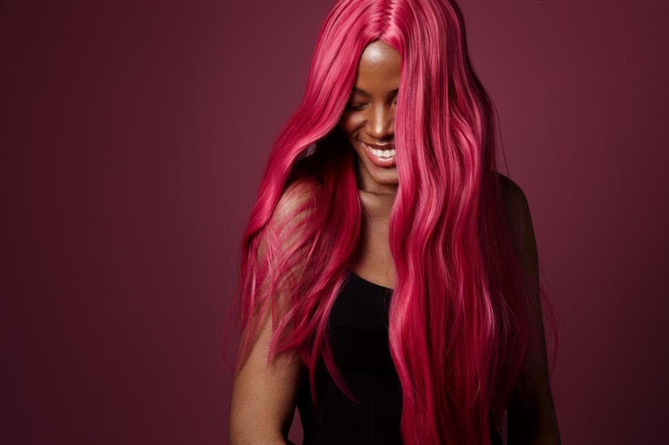 Free Image of Black woman with pink hair happy and smiling. creative hair color 