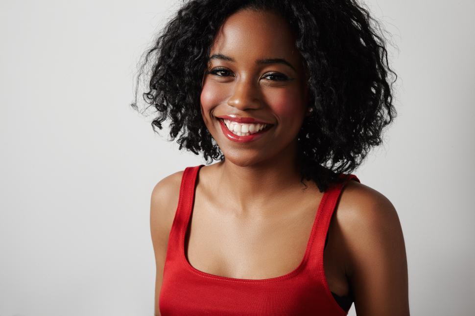 Free Image of black woman in red evening slim dress, smiling and looking at the camera 