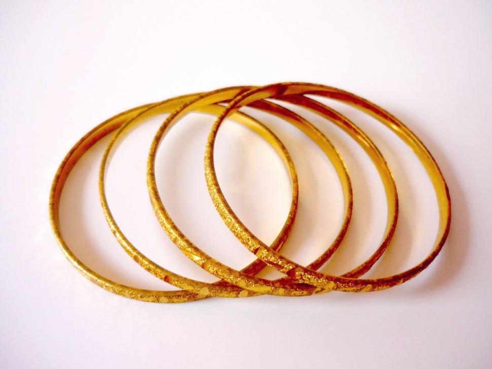 Free Image of Set of Five Gold Colored Rings on White Surface 