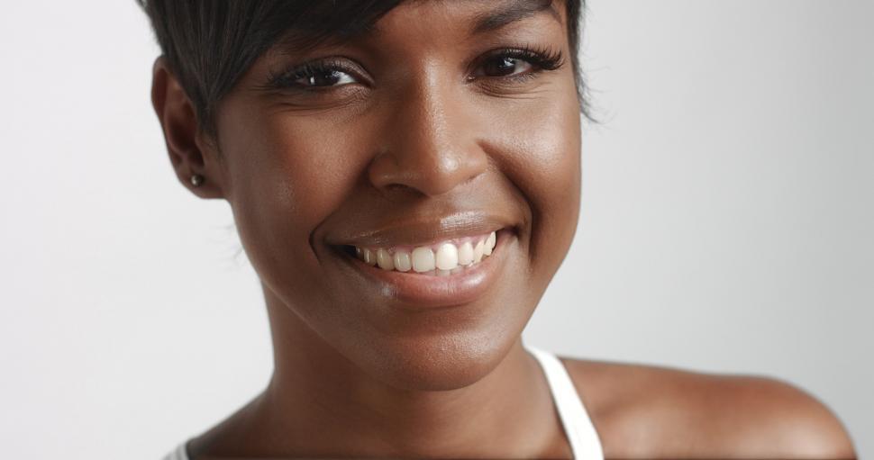 Free Image of Gorgeous black young woman posing, close up portrait, smiling at camera 