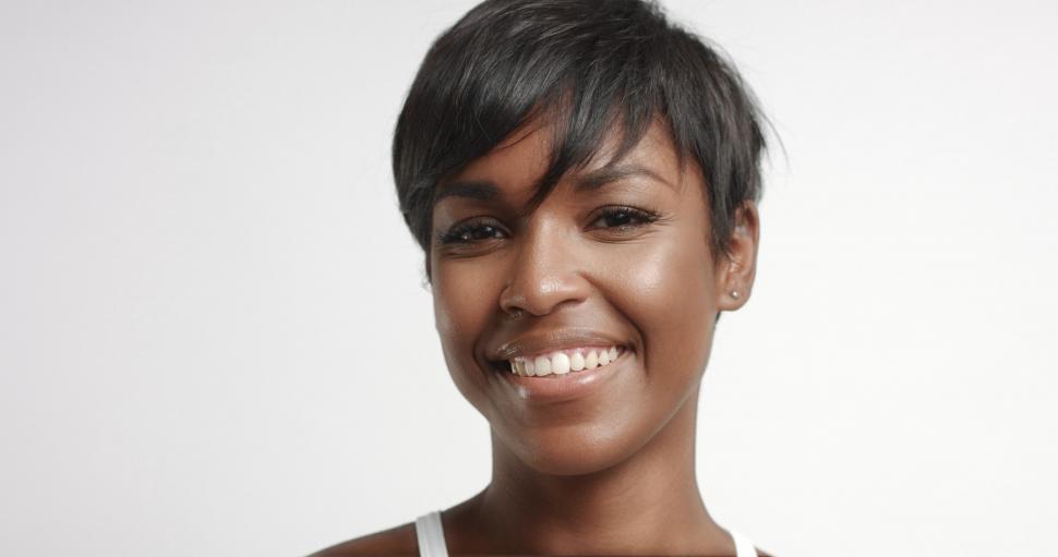 Free Image of Close up of gorgeous black young woman in studio, smiling at the camera 
