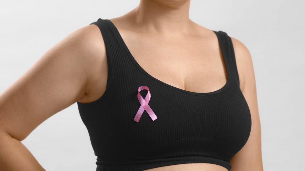 Free Image of Woman in a sports bra with a breast cancer awareness ribbon 