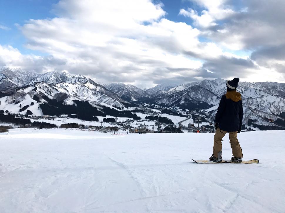 Free Image of A person on a snowboard looking at mountains 