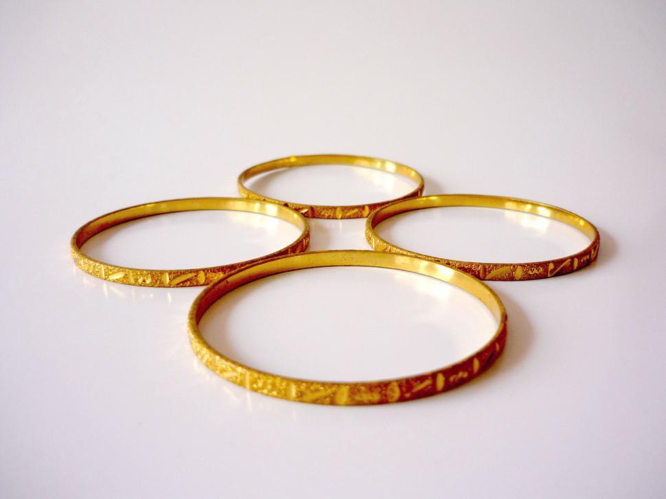 Free Image of Four Gold Rings on White Surface 
