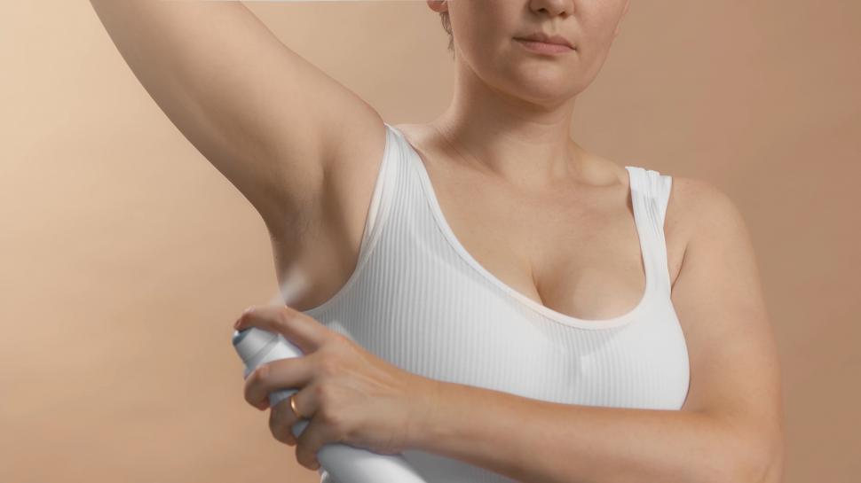 Free Image of Woman applying deodorant 
