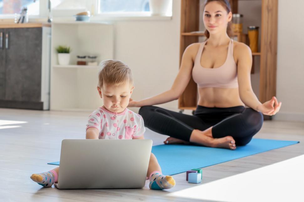 Free Image of A woman and child sitting on a yoga mat 