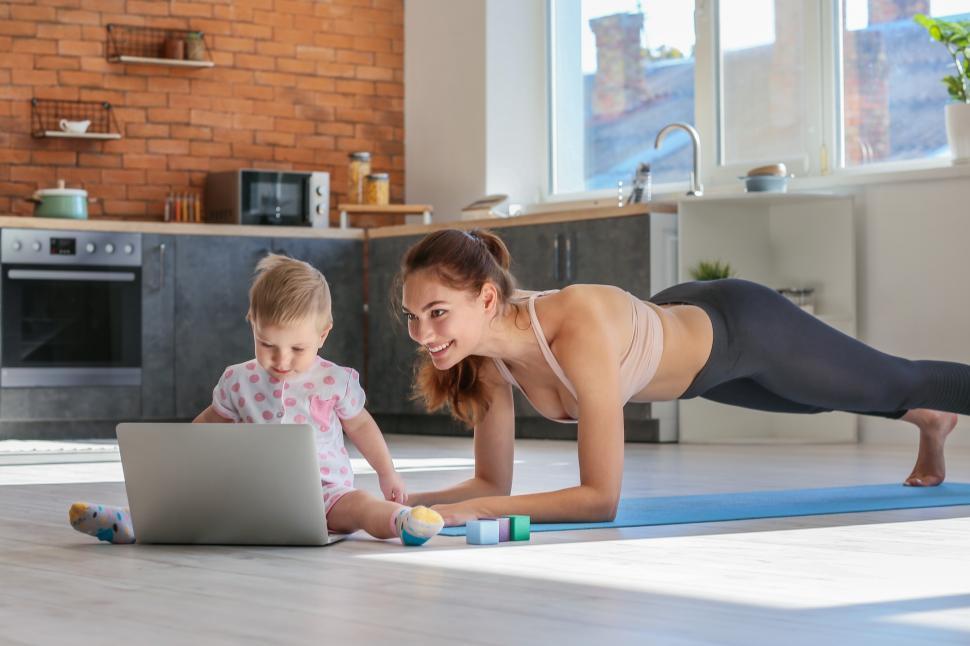 Free Image of A woman and a baby doing plank on a mat 