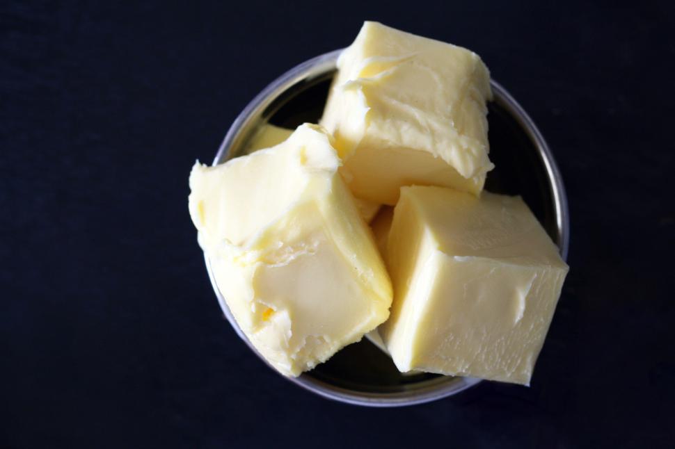 Free Image of A bowl of butter on a black surface 