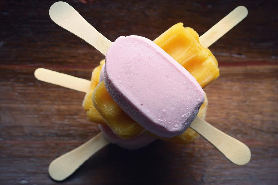 Free Image of A stack of popsicles on a wood table 