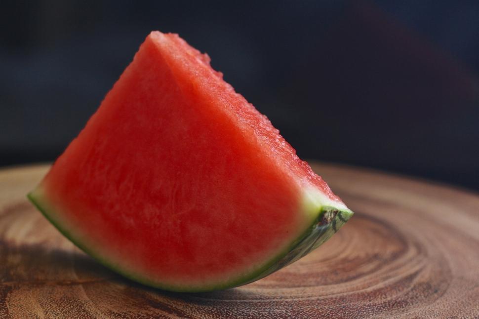 Free Image of A slice of watermelon on a wood surface 