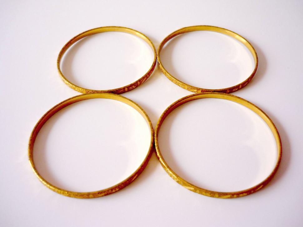 Free Image of Four Gold Rings on White Surface 