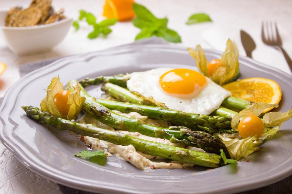 Free Image of A plate of asparagus with a egg and physalis 