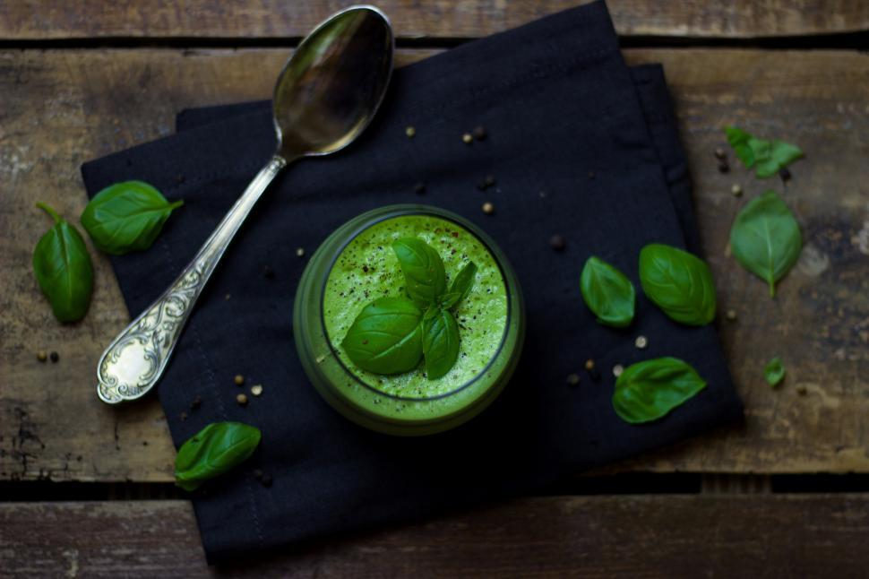 Free Image of A green soup in a glass with basil leaves on top 