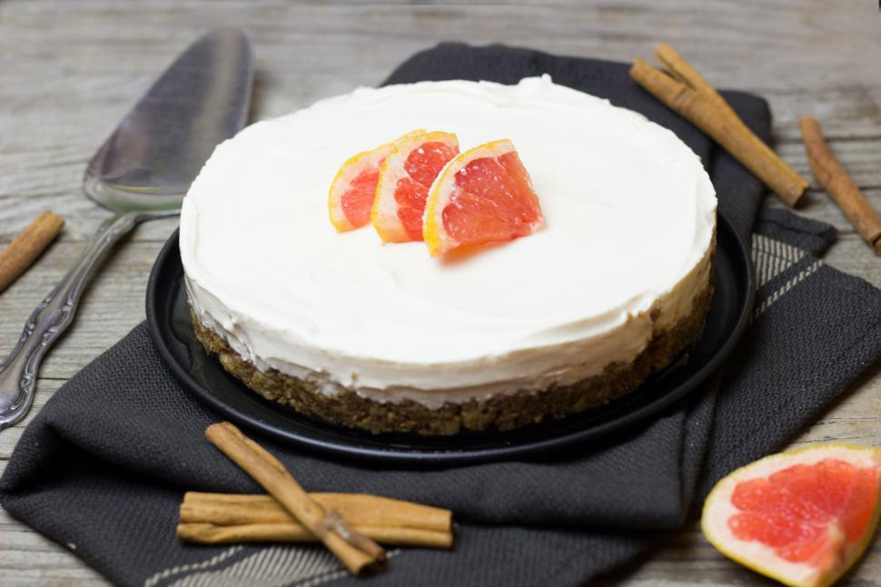 Free Image of A cake with white frosting and orange slices on top 