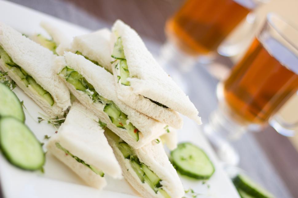 Free Image of A plate of sandwiches with cucumbers and a drink 
