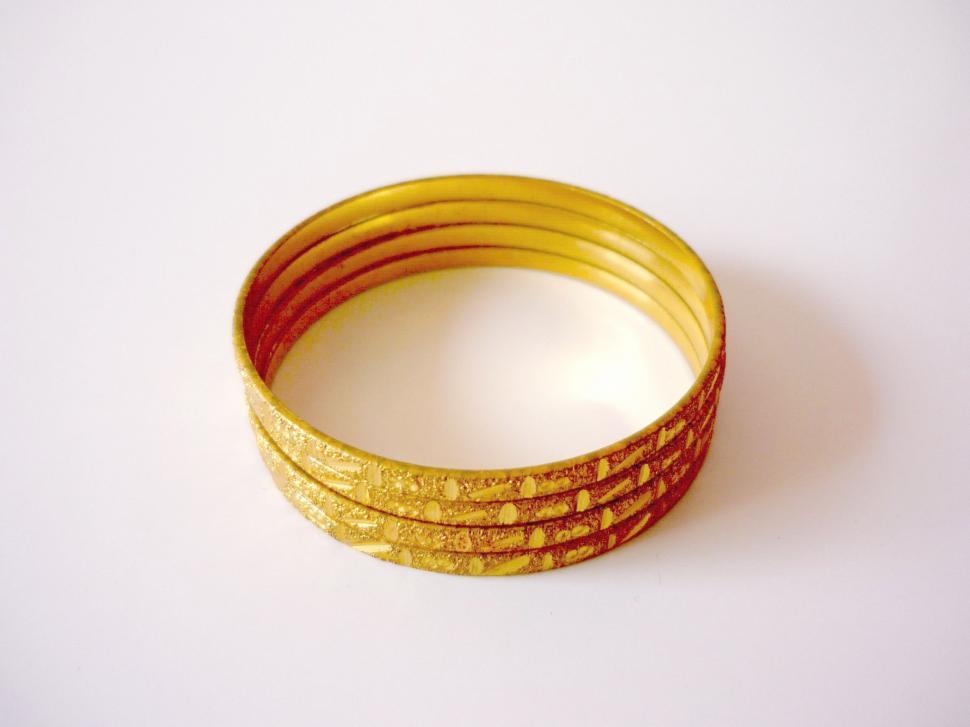 Free Image of Stack of Yellow Bangles on White Surface 