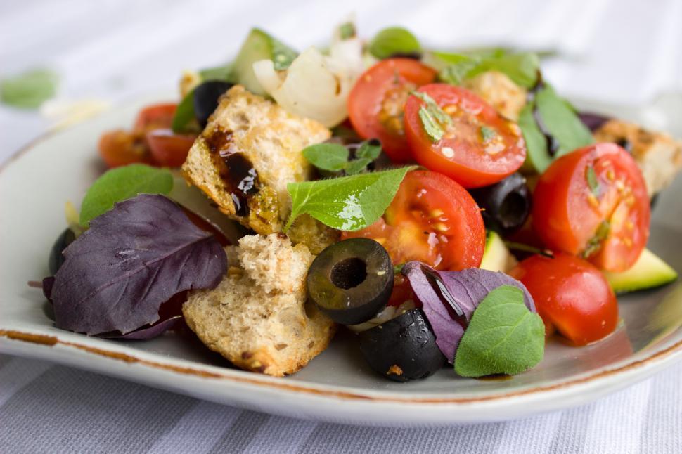 Free Image of A plate of salad with tomatoes olives and basil 