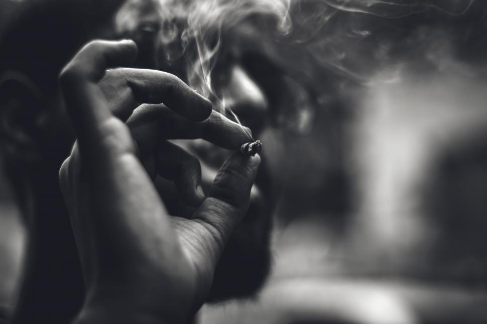 Free Image of A close up of a man smoking a cigarette 