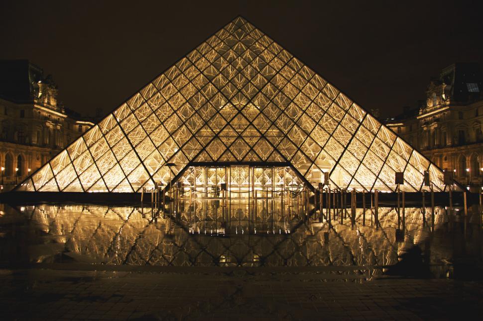 Free Image of Louvre glass pyramid building with lights in Paris, France 