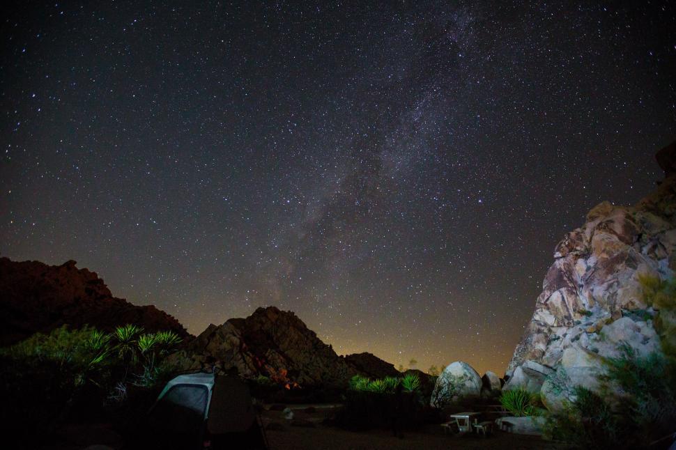 Free Image of A starry night sky over a rocky area 
