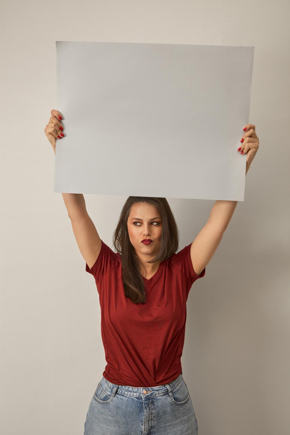 Free Image of A woman holding a white sign over her head 