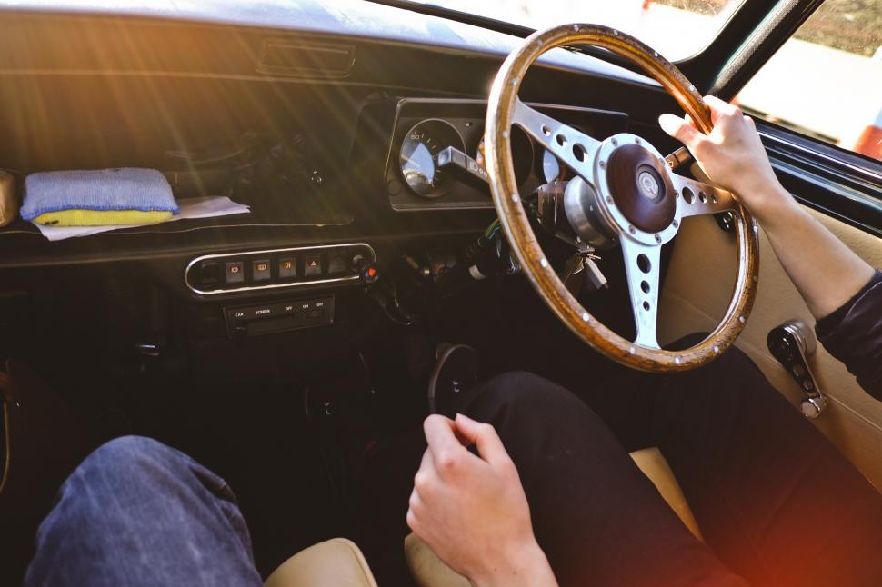 Free Image of A person holding a steering wheel in a car 