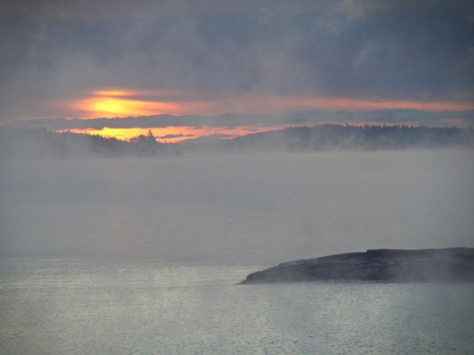 Free Image of A foggy lake with a small island in the middle 