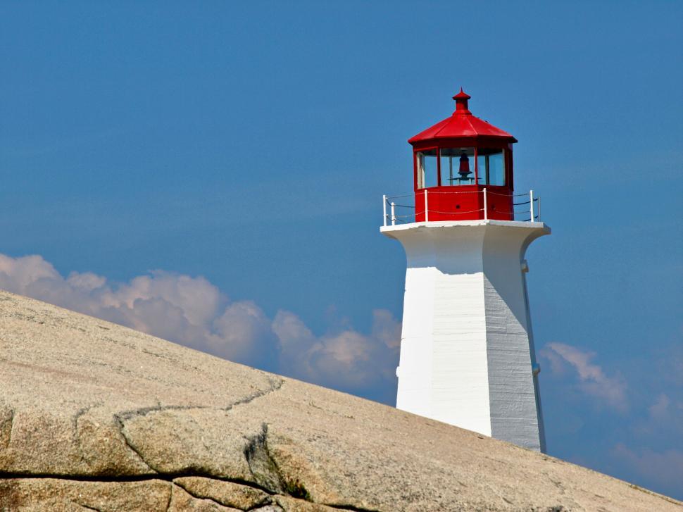 Free Image of A lighthouse on a rocky hill 