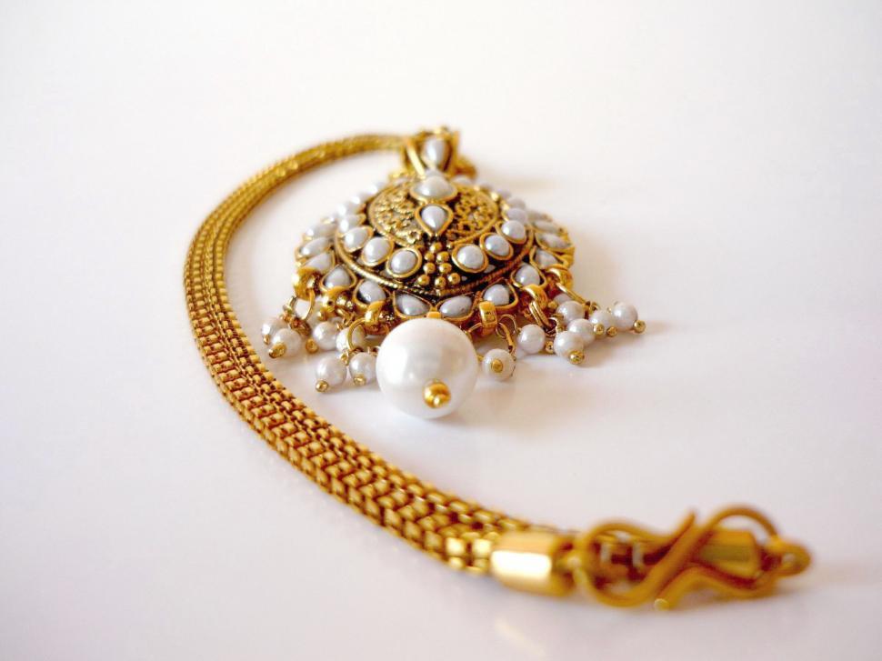 Free Image of Elegant Gold Necklace With Pearls and Chain 