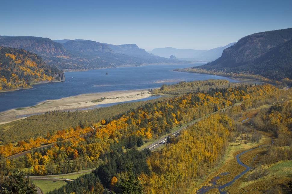 Free Image of A river with trees and mountains in the background with columbia river gorge in the background 